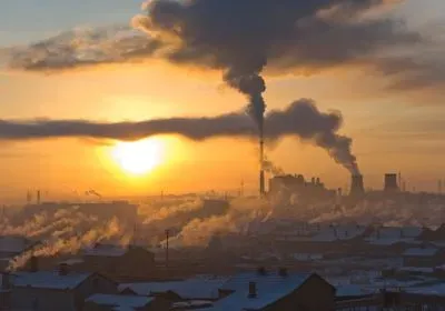 a winter cityscape with smokestacks